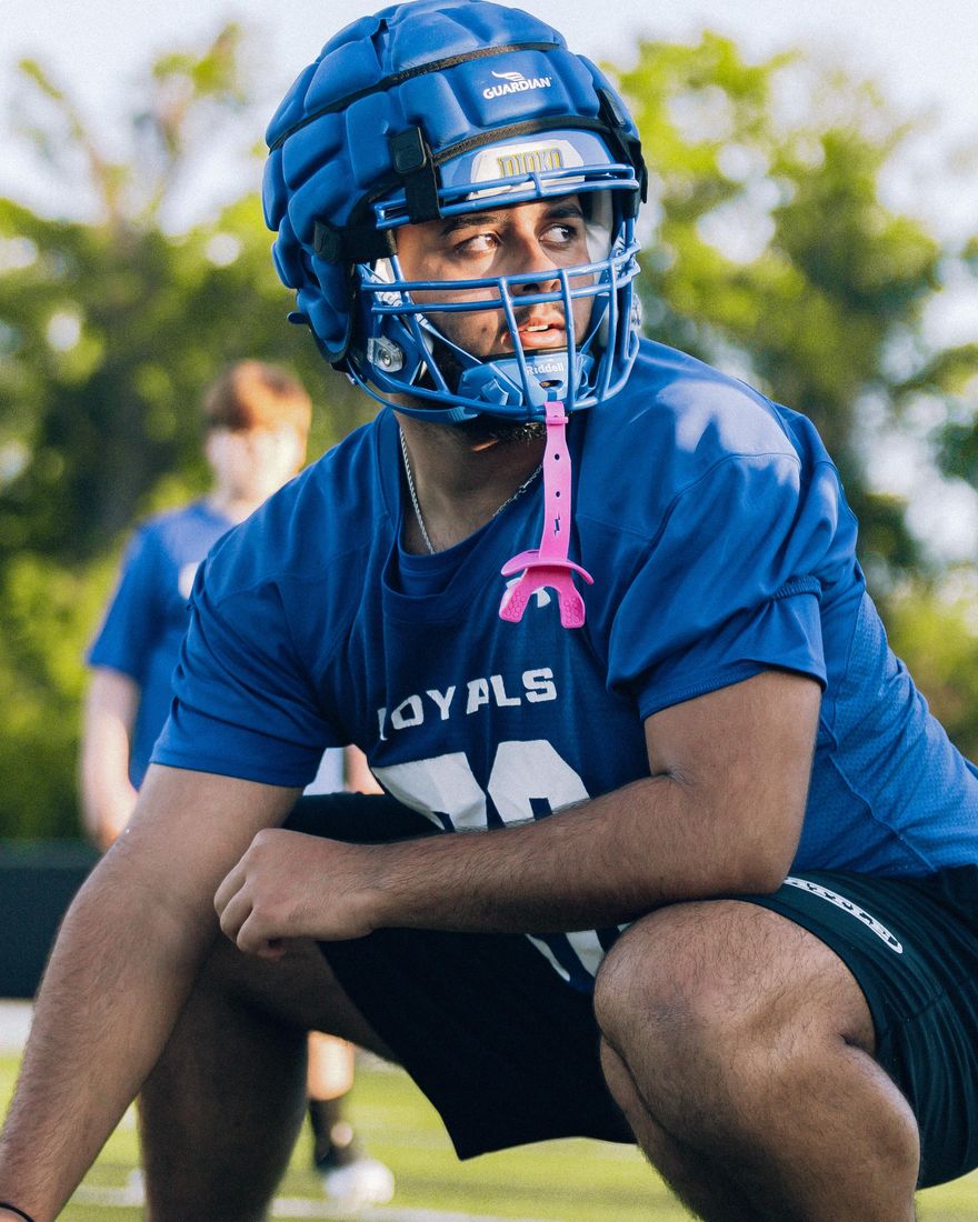 Dominic Miranda in his royal-blue The First Academy Royals jersey, set in a lineman's stance