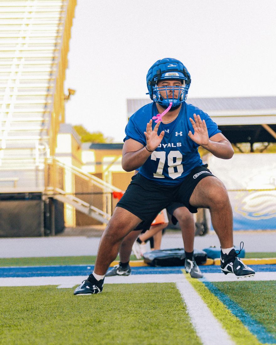Dominic Miranda at practice in a two-point stance, hands up at the line